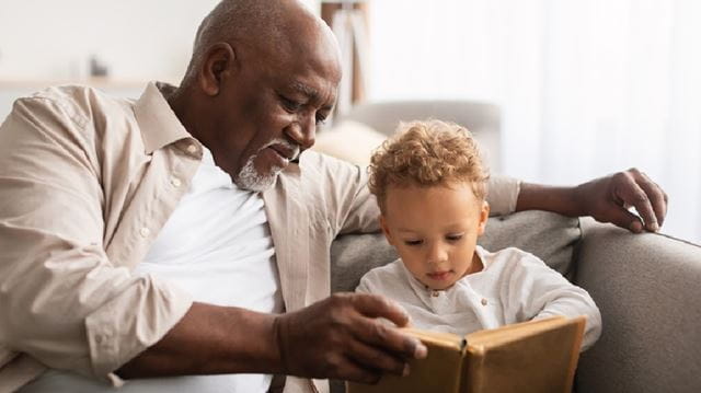 Dad reading book with son